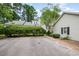 Exterior view of a home featuring white siding, black shutters, a brick walkway, and manicured hedges at 384 Lyndfield Cl W, Pittsboro, NC 27312