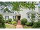 Charming home with a brick walkway leading to the entrance, complemented by lush landscaping and mature trees at 384 Lyndfield Cl W, Pittsboro, NC 27312