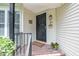 Welcoming front porch with a black door, brick floor, potted plants, and a cozy, inviting ambiance at 384 Lyndfield Cl W, Pittsboro, NC 27312