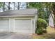 Exterior view of a two-car garage featuring white siding and a gray shingle roof at 384 Lyndfield Cl W, Pittsboro, NC 27312