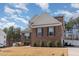 Side view of a well-kept two-story home with brick accents, surrounded by trees and a fenced-in yard at 40 Ironwood Blvd, Youngsville, NC 27596