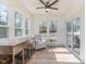 Bright sunroom with a ceiling fan, lots of windows, hardwood floors, and comfortable seating at 40 Ironwood Blvd, Youngsville, NC 27596
