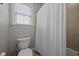 Bathroom featuring a toilet, shower with curtain, and natural light at 4001 Falls River Ave, Raleigh, NC 27614