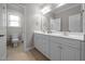 Bright bathroom with double vanity sinks, tile flooring, and white cabinets at 4001 Falls River Ave, Raleigh, NC 27614