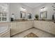 Bright bathroom with double vanity, granite counters, tile floors, and large mirrors at 4001 Falls River Ave, Raleigh, NC 27614