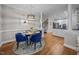 Dining room with hardwood floors, modern chandelier, and open to the kitchen at 4001 Falls River Ave, Raleigh, NC 27614
