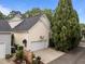View of attached garage with black roof, basketball hoop, and green trash bins on long driveway at 4001 Falls River Ave, Raleigh, NC 27614
