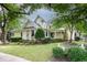 Charming yellow two-story home featuring a welcoming front porch and beautifully landscaped front yard at 4001 Falls River Ave, Raleigh, NC 27614