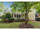 Charming yellow two-story home featuring an inviting front porch and lush landscaping at 4001 Falls River Ave, Raleigh, NC 27614