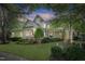 Inviting two-story home with a charming front porch, beautiful landscaping, and mature trees at 4001 Falls River Ave, Raleigh, NC 27614