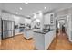 Spacious kitchen with stainless steel appliances, double islands, white cabinets, and hardwood floors at 4001 Falls River Ave, Raleigh, NC 27614