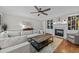 Cozy living room featuring a fireplace, built-in shelving, a large sofa, and hardwood floors at 4001 Falls River Ave, Raleigh, NC 27614
