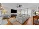 This modern living room boasts hardwood floors, ceiling fan and large sectional sofa at 4001 Falls River Ave, Raleigh, NC 27614