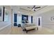 Bright main bedroom with blue accent wall, ensuite bath, and large windows with curtains at 4001 Falls River Ave, Raleigh, NC 27614