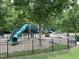 Community playground with multiple slides, climbing structures, and fenced perimeter at 4001 Falls River Ave, Raleigh, NC 27614