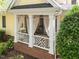 Inviting porch with brick base, string lights, white curtains, and comfortable seating, creating a cozy outdoor space at 4001 Falls River Ave, Raleigh, NC 27614