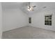 Bright bedroom with plush carpeting, ceiling fan, and two windows providing natural light at 412 Hay River St, Garner, NC 27529