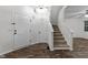 Welcoming foyer featuring dark wood-look floors and a staircase, creating a grand entrance at 412 Hay River St, Garner, NC 27529