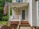 Inviting front porch with American flag, hanging planters, and brick accents at 412 Hay River St, Garner, NC 27529
