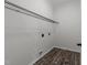 A convenient laundry room with dark wood-look flooring and a wire shelf for storage at 412 Hay River St, Garner, NC 27529
