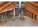 Spacious attic is ready for custom renovations with exposed wooden beams and a brick chimney at 417 N Gurney St, Burlington, NC 27215