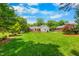 Large grassy backyard with mature trees and landscaping at 417 N Gurney St, Burlington, NC 27215