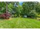 Expansive backyard featuring lush lawn, mature trees, garden shed, and vibrant landscaping at 417 N Gurney St, Burlington, NC 27215