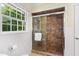 Bathroom shower featuring brown tile and glass shower door with an adjacent window at 417 N Gurney St, Burlington, NC 27215