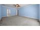 Spacious bedroom features light blue walls, neutral carpet, ceiling fan, and access to the ensuite bathroom at 44 Supreme Dr, Lillington, NC 27546