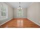 Inviting dining area with a chandelier, a large window, and hardwood flooring, perfect for Gathering gatherings at 44 Supreme Dr, Lillington, NC 27546