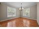 Bright dining room with two large windows, chandelier lighting, and hardwood flooring at 44 Supreme Dr, Lillington, NC 27546