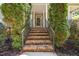 The brick steps lead to the front door, framed by lush greenery at 44 Supreme Dr, Lillington, NC 27546