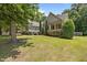 Beautiful home featuring a well-manicured lawn, mature trees, and charming curb appeal at 44 Supreme Dr, Lillington, NC 27546