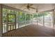 Relaxing screened porch featuring wood flooring, multiple fans, and views of the backyard at 44 Supreme Dr, Lillington, NC 27546