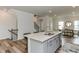 Open-concept kitchen with a large island, stainless steel appliances, and views of the dining and staircase at 474 Carolina Springs Dr, Apex, NC 27539