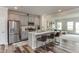 Modern kitchen features stainless steel appliances, a large island with bar stools and wood-look flooring at 474 Carolina Springs Dr, Apex, NC 27539