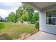 Green backyard with a covered back porch, large trees, and a play set at 520 Flip Trl, Cary, NC 27513
