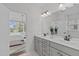 Bright bathroom with double sink vanity, large mirror, and entryway to main bedroom at 520 Flip Trl, Cary, NC 27513