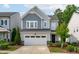Charming two-story home with a two-car garage, manicured landscaping, and light blue accents at 520 Flip Trl, Cary, NC 27513