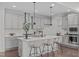 Modern kitchen with a large island, stainless steel appliances, and stylish pendant lighting at 520 Flip Trl, Cary, NC 27513