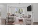 Bright living room featuring hardwood floors, stylish furnishings, a large window with backyard view and a cozy fireplace at 520 Flip Trl, Cary, NC 27513