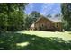 Expansive backyard featuring a well-maintained lawn and a charming brick house with a wooden deck at 5464 Bass Mountain Rd, Snow Camp, NC 27349