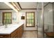 Bathroom with double vanity, wood-trimmed window, and glass-enclosed shower at 5464 Bass Mountain Rd, Snow Camp, NC 27349
