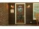 Attractive front door adorned with a wreath, complemented by brick and wood siding at 5464 Bass Mountain Rd, Snow Camp, NC 27349