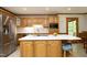 The kitchen features a large island with seating, stainless steel appliances and wooden cabinetry at 5464 Bass Mountain Rd, Snow Camp, NC 27349