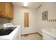Bright laundry room with washer, dryer, cabinets, and utility sink at 5464 Bass Mountain Rd, Snow Camp, NC 27349