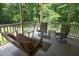 Covered porch featuring a wooden swing and comfortable seating arrangement at 5464 Bass Mountain Rd, Snow Camp, NC 27349