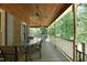 Long, covered porch with fan and seating overlooking lush greenery at 5464 Bass Mountain Rd, Snow Camp, NC 27349