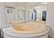 Large soaking tub, with tile surround, sits under expansive mirrors and bright lighting in this bathroom at 558 Christys Way, Roxboro, NC 27574