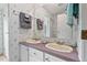 Bathroom featuring a double vanity with beige sinks, white cabinets, and a shower at 558 Christys Way, Roxboro, NC 27574